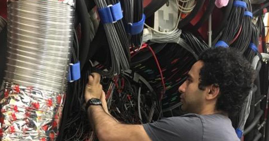 Regina graduate student Ahmed Foda cabling the LED pulser system for the GlueX Barrel Calorimeter